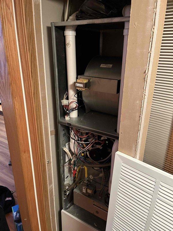 Diagnosed and replaced failed inducer draft motor on 31-year-old furnace that was producing loud clunking noises. Motor was drawing 2.6 amps (exceeding 2.35 amp rating) and overheating, causing audible clicking that resonated through ductwork. Removed access panel to perform amperage testing and complete necessary component replacement.
