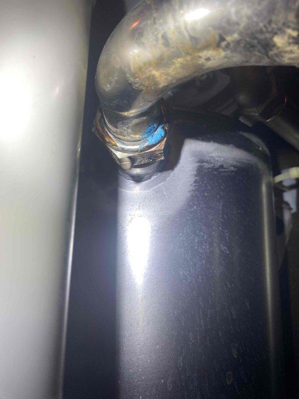 Responded to service call for an 11-year-old boiler with active leak. Diagnostic inspection revealed leaking gasket at pipe connection. Tightened connection nut to resolve the leak while maintaining system operation. Circulation pump and associated plumbing components inspected and verified to be functioning properly after repair.