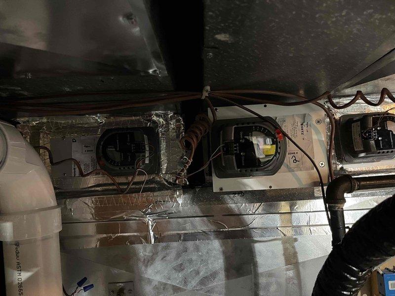 Diagnosed and resolved multiple system issues including a mechanically binding zone damper which was reoriented to restore proper function, though it shows signs of imminent failure and may need replacement pending warranty verification. Identified unsecured transformer as source of reverberating hum, which requires rubber pad installation and proper anchoring to eliminate vibration. Corrected thermostat programming error that was causing system to activate two hours before intended start time, adjusting settings to begin heating at wake time rather than reaching setpoint by wake time.