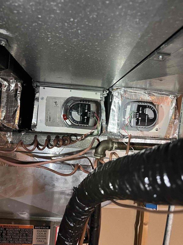 Diagnosed and resolved multiple system issues including a mechanically binding zone damper which was reoriented to restore proper function, though it shows signs of imminent failure and may need replacement pending warranty verification. Identified unsecured transformer as source of reverberating hum, which requires rubber pad installation and proper anchoring to eliminate vibration. Corrected thermostat programming error that was causing system to activate two hours before intended start time, adjusting settings to begin heating at wake time rather than reaching setpoint by wake time.