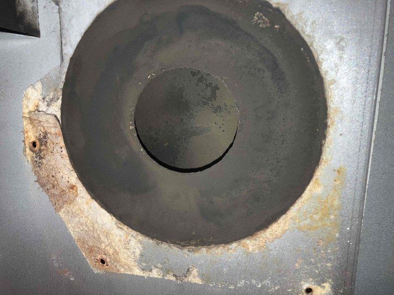 Replaced severely deteriorated inducer motor assembly that was causing system overheating. Visual inspection revealed significant corrosion, rust damage, and soot buildup throughout the assembly. Inducer fan wheel showed extensive wear with damaged blades and mounting plate exhibited heavy discoloration and rust penetration around the vent opening.