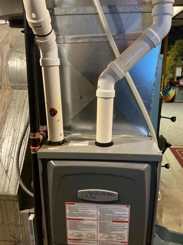 Responded to customer concern regarding exposed exhaust pipe on Armstrong Air furnace. Upon inspection, found PVC exhaust pipe with unsealed hole allowing potential exhaust gas infiltration into home. Properly sealed the hole using RTV sealant and installed blue plug to ensure safe system operation and prevent carbon monoxide hazard.