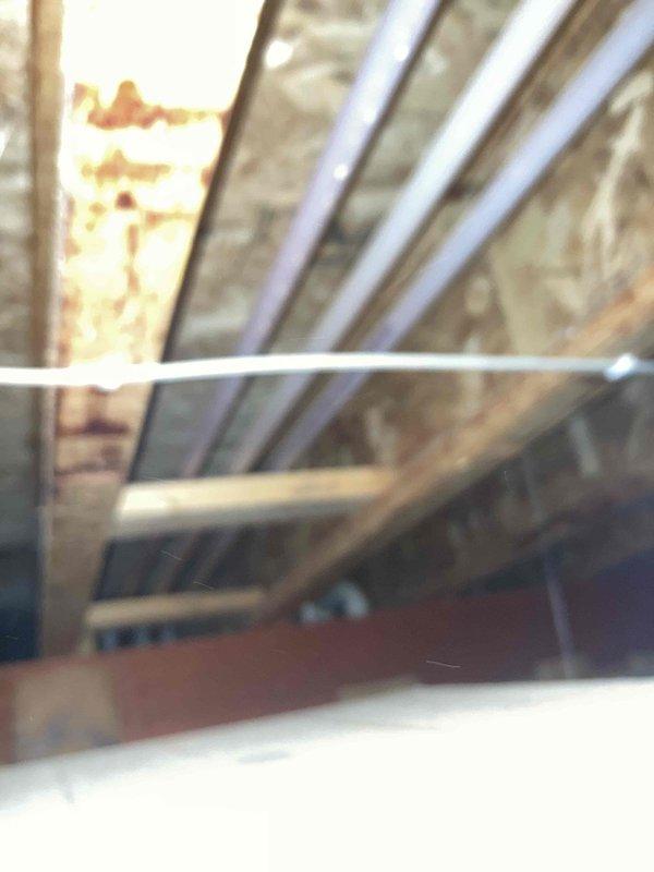 Performed diagnostic assessment on 18-year-old tankless water heater experiencing intermittent hot water delivery issues. System was operational but not distributing hot water consistently to required locations. Conducted thorough cleaning of unit components to improve performance. Noted structural conditions in surrounding area, including evidence of moisture exposure on wooden joists and existing PVC plumbing configuration.