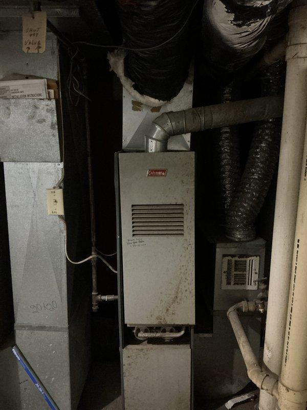 Responded to no heat complaint for residence with Coleman furnace showing significant age. Diagnosed faulty thermostat as source of heating failure. Ambient temperature at arrival was 49.1°F. Replaced thermostat and verified proper system operation, restoring heat to home.