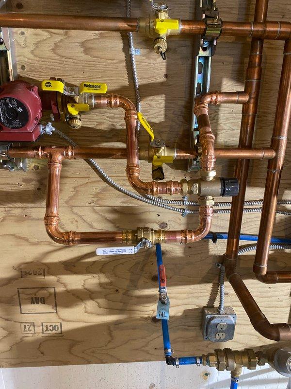 Successfully installed mixing valve as requested per Caden's estimate. The installation was integrated with the existing copper plumbing network featuring multiple shutoff valves. System now properly configured with all connections secure and operational.