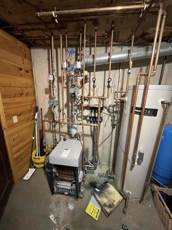 Performed inspection on an aged Slant Fin boiler reported to be making noise, finding CO leakage from deteriorated heat exchanger and degraded antifreeze in system. Observed significant moisture damage and possible mold growth on surrounding infrastructure. Advised customer that heat exchanger replacement would be difficult/costly as manufacturer is out of business and recommended system cleaning, flush with new antifreeze, and potential replacement of original zone pumps and valves.