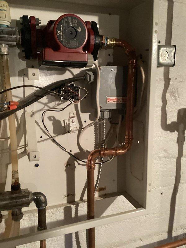 Completed repiping to isolate heat exchanger from the system and establish a dedicated in-floor heating loop directly from the boiler. Installed two Grundfos circulation pumps with appropriate flow meters and gauges to monitor system performance. Copper piping was properly fitted with brass connections and secured to wall mounts, ensuring an efficient hydronic heating configuration with separate control zones.