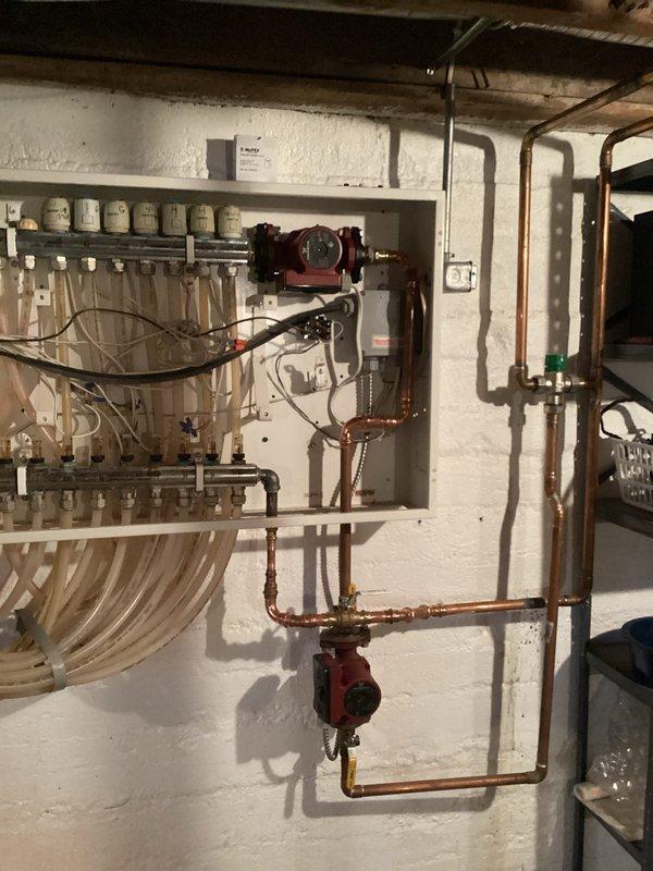 Completed repiping to isolate heat exchanger from the system and establish a dedicated in-floor heating loop directly from the boiler. Installed two Grundfos circulation pumps with appropriate flow meters and gauges to monitor system performance. Copper piping was properly fitted with brass connections and secured to wall mounts, ensuring an efficient hydronic heating configuration with separate control zones.