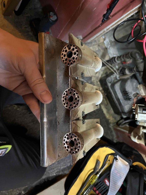 Completed partner plan annual inspection on 15-year-old furnace, identifying multiple issues including flame sensor with dead spots and high resistance, corroded igniters and burners, dirty blower wheel, and discoloration on the control board. Documentation included photographs of the burner assembly showing significant corrosion and the functioning control board for reference. Customer elected to proceed with comfort advisor consultation for replacement options.