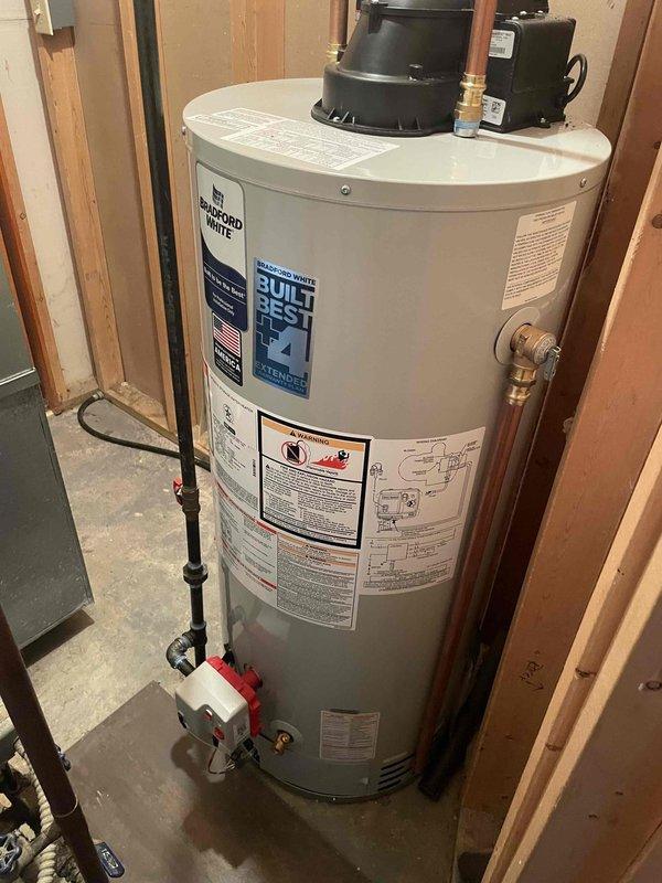 Successfully installed a Bradford White 40-gallon LP power vent water heater. Disconnected furnace intake/exhaust pipe to facilitate removal of old unit, stripped back gas piping, positioned new heater, then connected to existing vent piping. Installed new shutoff valve for water lines while reusing existing gas shutoff valve, and reconnected furnace PVC piping to complete the installation.