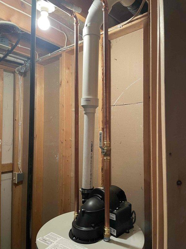 Successfully installed a Bradford White 40-gallon LP power vent water heater. Disconnected furnace intake/exhaust pipe to facilitate removal of old unit, stripped back gas piping, positioned new heater, then connected to existing vent piping. Installed new shutoff valve for water lines while reusing existing gas shutoff valve, and reconnected furnace PVC piping to complete the installation.