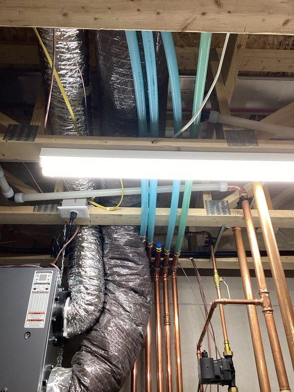 Inspected hydronic infloor heating system on main floor and identified damaged tubing caused by nail penetration requiring replacement. Documented unconnected manifold and absence of glycol in the system. Met with insurance adjuster on-site to evaluate repair scope, which will involve opening drywall and repiping the infloor heat system in this new construction.