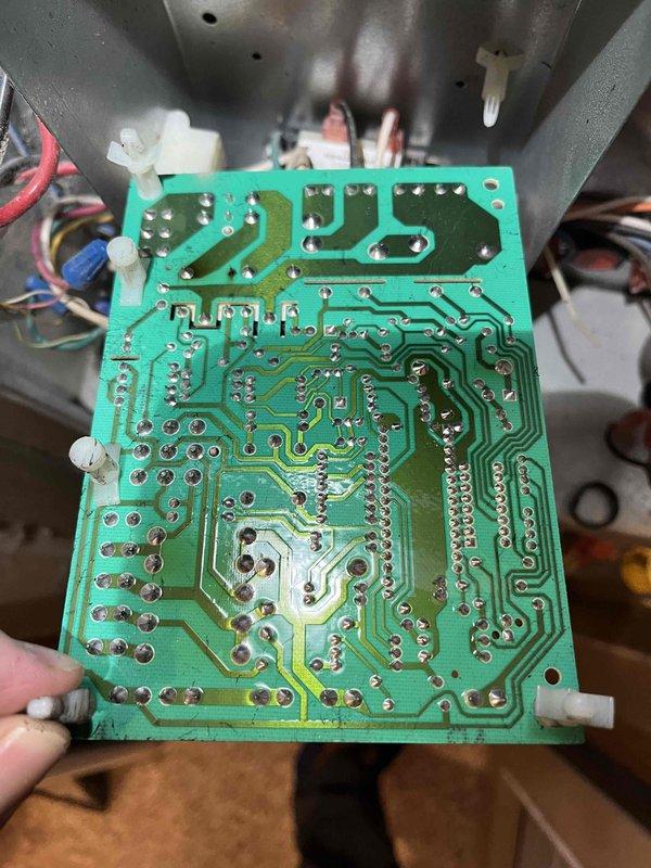 # Service Report: No Heat Call - Furnace Control Board Failure

Responded to no heat call on furnace system over 10 years old. Upon arrival and initial inspection, discovered significant heat damage to the main control board and associated components. Visual examination revealed melted areas on the circuit board with multiple electronic components showing thermal stress and discoloration. 

Performed diagnostic assessment and documented the extent of damage through photographic evidence, capturing both the component side and solder side of the control board to show heat-affected areas, damaged traces, and compromised electronic components including resistors, capacitors, and integrated circuits. The control board exhibited clear signs of electrical failure with visible burn marks and deteriorated connections.

Presented repair options to customer including component replacement and system evaluation. Customer elected to proceed with comfort advisor consultation for comprehensive system