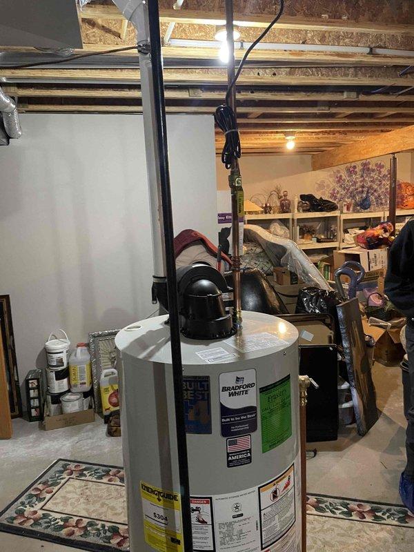 # Job Summary

Installed 50-gallon natural gas power vent water heater per approved estimate. Reused existing shutoff valve, connected to existing 2" vent piping, established gas supply connection, and completed all water line connections to bring unit into full operation.

# Work Performed

Removed and disposed of existing water heater from basement utility area. Positioned new Bradford White 50-gallon natural gas power vent water heater in designated location on concrete floor. Verified adequate clearances for safe operation and maintenance access.

Connected cold water supply line to tank inlet using existing shutoff valve as specified. Installed hot water outlet connections to existing distribution piping. Pressure tested all water connections to verify leak-free installation and proper seal integrity.

Established natural gas supply connection from existing gas line to water heater gas valve. Performed leak test on all gas connections using approved leak detection solution. Verifi