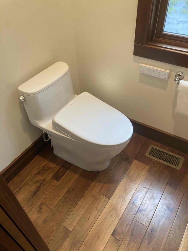 Installed customer-supplied one-piece toilet in bathroom with proper seating, water supply connection, and wax ring seal. Inspected bathtub drain mechanism and addressed operation difficulty to ensure smooth opening and closing functionality. All fixtures tested for proper operation and verified no leaks present upon completion.