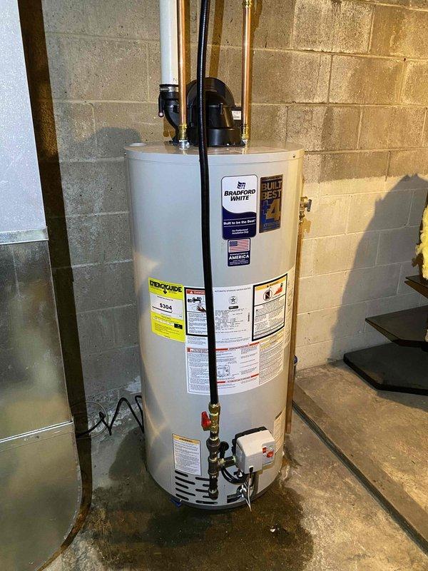 Successfully removed and disposed of existing water heater and installed a new 50-gallon Bradford White natural gas power-vent water heater in basement utility area. Connected all supply and discharge plumbing lines with proper shut-off valves, installed temperature and pressure relief valve with code-compliant discharge piping, and verified all gas connections for safe operation. Tested unit for proper ignition, venting, and temperature control, ensuring all manufacturer specifications and local plumbing codes were met upon completion.