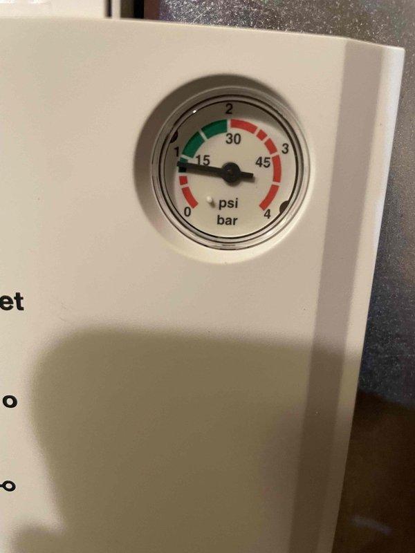 Completed annual prepaid maintenance inspection on boiler system. Upon inspection, discovered heat exchanger failure with extensive rust and corrosion throughout the finned coil assembly, compromising system integrity and safety. Documented equipment condition with photographs showing deteriorated heat exchanger fins with heavy oxidation and pressure gauge reading approximately 15 PSI. Informed customer of failed component requiring repair or replacement to restore safe operation.