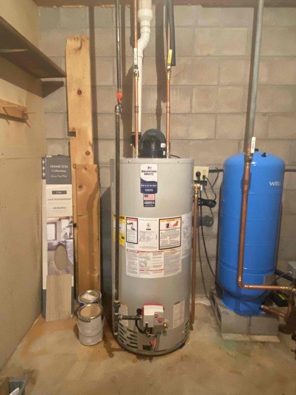 Installed a Bradford White 50-gallon LP power vent water heater in basement utility room. Performed minor alterations to existing water lines, gas line, and venting system to accommodate the new unit. Connected all plumbing and gas connections, installed ZCOV control system on top of tank, verified proper operation of temperature/pressure relief valve, and confirmed system functionality upon completion.
