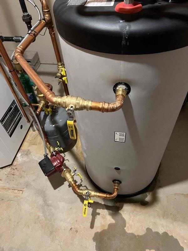 Responded to service call for leaking indirect water heater with heating fluid visible at top of unit. Upon inspection, identified fluid seeping from both the base of the tank and near the electronics box at the top, indicating a compromised internal heat exchanger. Locked out the unit immediately to prevent potential antifreeze contamination of the domestic water supply and provided replacement estimates to address the failed heat exchanger.