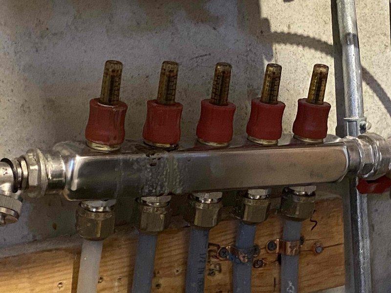 Completed annual heat inspection on 5-year-old boiler system under prepaid maintenance plan. Found debris accumulation in condensate trap, which was thoroughly cleaned to ensure proper drainage and system operation. Inspected radiant heating manifold assembly with five zone distribution points, confirming all zone valves and PEX connections were functioning properly.