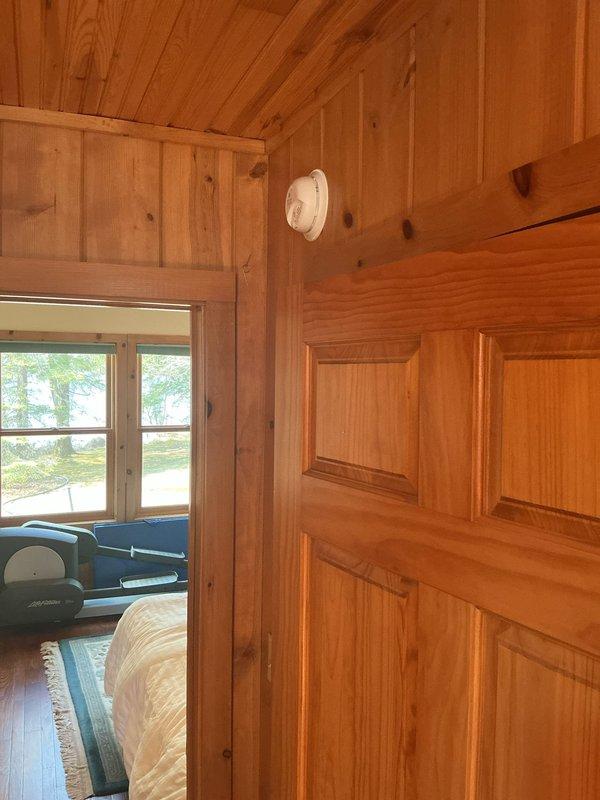 Completed electrical prepaid inspection of property. Accessed premises using key from lockbox located under electrical box on west side of garage. Performed comprehensive electrical system evaluation and identified two items requiring attention. Documented findings with photographs showing interior wood-paneled structure with smoke detector installation and floor-level electrical components including metallic cylindrical device with visible mechanical connections. Provided customer with detailed options for addressing identified electrical concerns.