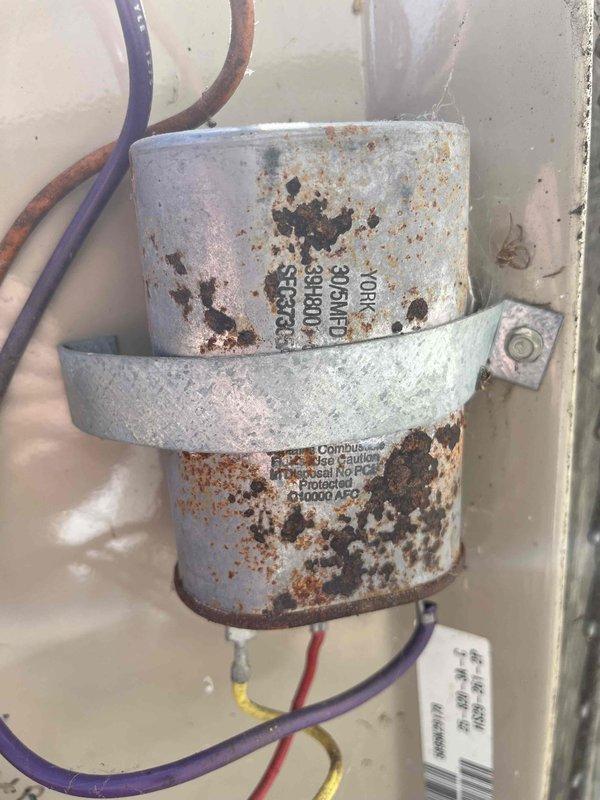 Responded to no cooling complaint on 8-year-old residential air conditioning system. Upon arrival, contacted property owner and gained access to perform diagnostic evaluation. Inspected outdoor condensing unit and identified failed dual run capacitor exhibiting severe corrosion and deterioration. Removed defective capacitor from electrical control panel and installed new replacement capacitor with proper microfarad ratings. Verified all electrical connections were secure, tested system operation, and confirmed unit returned to normal cooling function.