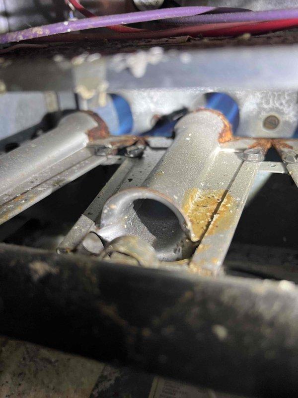 Responded to service call for furnace making buzzing noise at boat house location. Upon inspection, identified inducer motor exhibiting signs of bearing failure causing the reported noise. Observed significant corrosion on heat exchanger components and pipe connections throughout the unit. Documented equipment condition with photographs showing rust deterioration on metal assemblies and compromised component integrity. Provided customer with repair estimates for inducer motor replacement and recommended addressing corrosion issues to prevent further system degradation.