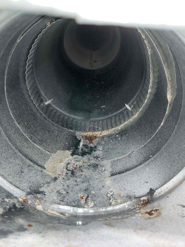 Completed comprehensive duct cleaning service for residential HVAC system. Removed accumulated dust, debris, and particulate matter from ductwork and ventilation components, including heavily soiled cylindrical vent sections with visible rust-colored deposits and significant dirt buildup. Inspected and documented condition of pleated air filters within filter rack housing, noting dust accumulation on filter media prior to system cleaning.
