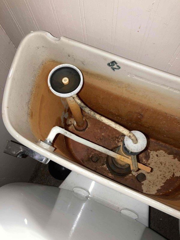 Completed de-winterization service on cabin plumbing system with no power available. Restored water supply to the property and inspected plumbing fixtures for proper operation. Noted significant rust and mineral buildup in toilet tank and partially disassembled shower valve requiring handle reinstallation upon completion of water restoration.