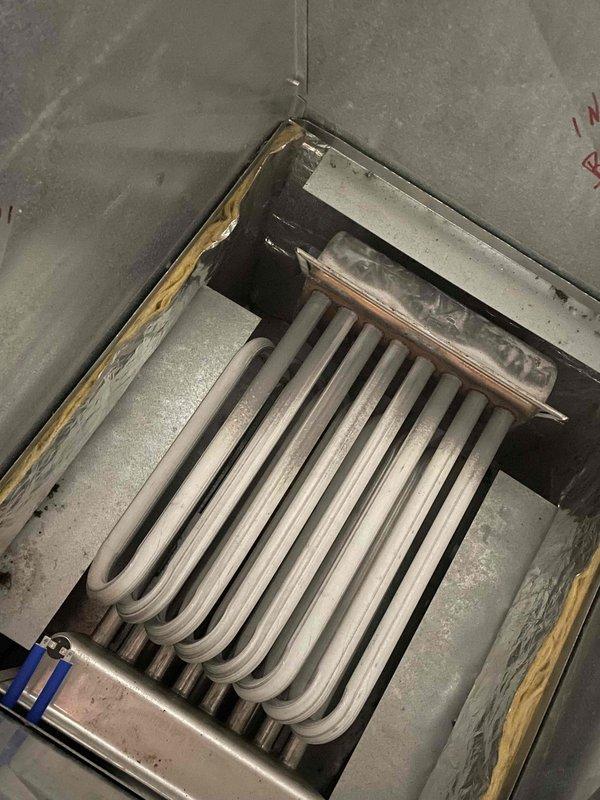Responded to emergency no-heat call for 20+ year old furnace at summer home with reported water leaking and unusual sounds. Upon inspection, discovered failed heat exchanger with visible cracks causing combustion gas leakage, water intrusion from deteriorated chimney flashing, and damaged electrical connections due to moisture exposure. Documented extensive corrosion on heat exchanger coils and yellowing insulation indicating prolonged heat stress and age-related deterioration. Performed combustion analysis and safety testing confirming unit unsafe for operation. System remains shut down due to cracked heat exchanger posing carbon monoxide hazard. Advised homeowner that repairs are not feasible given extent of heat exchanger failure and age of equipment; recommended complete furnace replacement for safety and reliability.