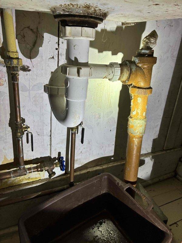 Completed cottage de-winterization and addressed plumbing issue in bathroom. Accessed property using provided key location and power box access per instructions. Upon inspection, identified failed P-trap under sink with active leak. Removed deteriorated white plastic P-trap assembly and installed new replacement trap, ensuring proper alignment and secure connections to drain tailpiece and waste line. Tested system for leaks and verified proper drainage function. All plumbing components now operational for seasonal use.