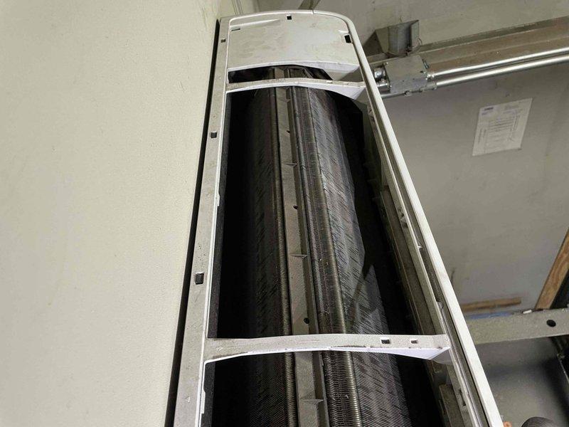 Responded to no cool call in server room with ambient temperature at 95°F. Upon inspection, found wall-mounted air handler with heavily clogged evaporator coil restricting airflow and preventing proper heat transfer. Coil exhibited significant dust and debris accumulation throughout fin assembly, causing unit to discharge warm air instead of cooling. Documented condition with photos and provided estimate for deep cleaning service to restore system operation and cooling capacity.