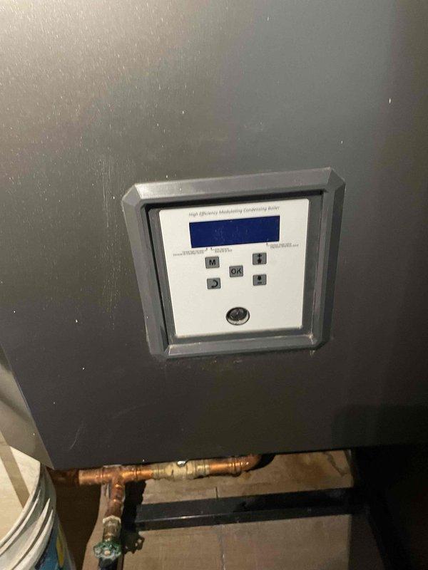 Responded to no heat call for high efficiency modulating condensing boiler over 10 years old. Upon inspection, found active leak on copper piping with visible corrosion and deterioration of pipe fittings. System was non-operational due to leaking component compromising boiler function. Documented conditions with photos showing affected piping, valve assembly, and boiler control panel. Provided repair/replace recommendation to restore heating system operation.