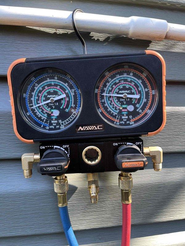 Responded to no cooling complaint and found system low on refrigerant with evaporator coil frozen. Connected manifold gauges to service ports and verified active refrigerant leak in the system through pressure readings. Presented options for nitrogen leak detection service versus full system evaluation by comfort advisor, with customer selecting comfort advisor consultation scheduled for same day.