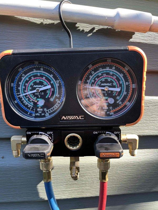 Responded to no cooling complaint and found system low on refrigerant with evaporator coil frozen. Connected manifold gauges to service ports and verified active refrigerant leak in the system through pressure readings. Presented options for nitrogen leak detection service versus full system evaluation by comfort advisor, with customer selecting comfort advisor consultation scheduled for same day.