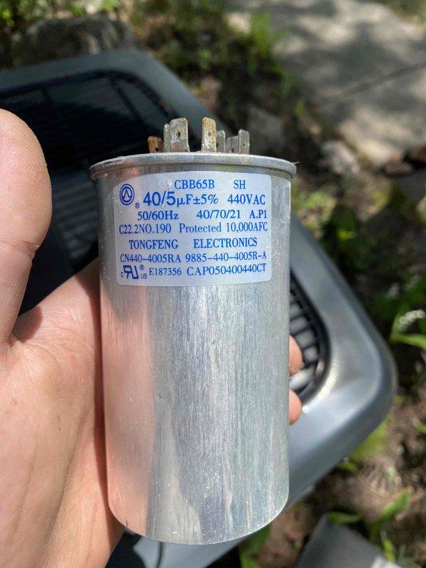 Responded to no cooling call on residential air conditioning system. Upon inspection, diagnosed failed dual run capacitor (40/5µF 440VAC) preventing compressor and condenser fan motor operation. Removed defective TONGFENG capacitor and installed new replacement unit, restoring proper system function. Verified all electrical connections, tested system operation, and confirmed adequate cooling performance before completing service call.
