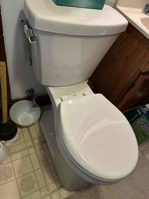Completed cottage de-winterization service including full toilet replacement in the bathroom and kitchen faucet replacement due to leaking. All fixtures were successfully installed and tested for proper operation, with new chrome two-handle faucet installed on double-basin stainless steel sink and new white porcelain toilet installed with functional flush mechanism.