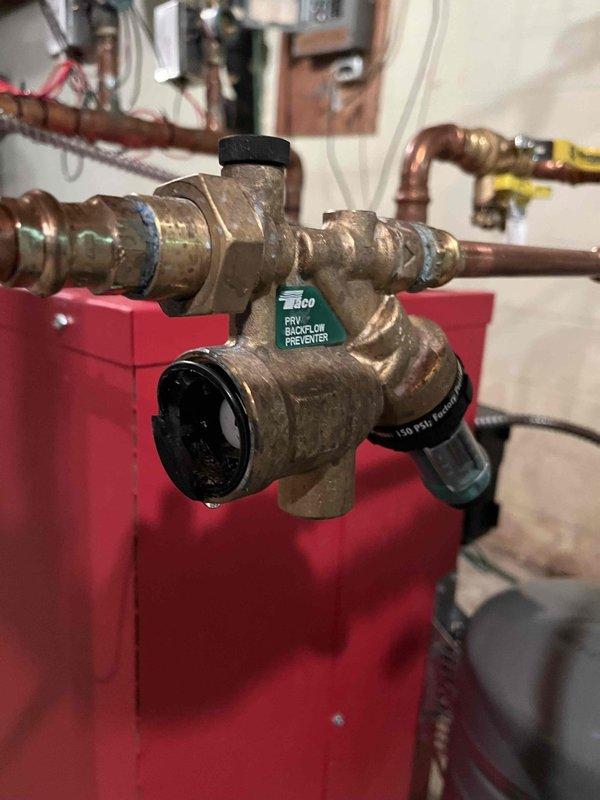 Responded to service call for broken backflow preventer and fill valve assembly on hydronic heating system. Removed failed brass backflow preventer/fill valve unit and replaced with new Caleffi backflow preventer and fill valve assembly, reconnecting copper supply lines with proper compression fittings. Verified system integrity and proper operation upon completion, ensuring water feed functionality was restored to heating system.