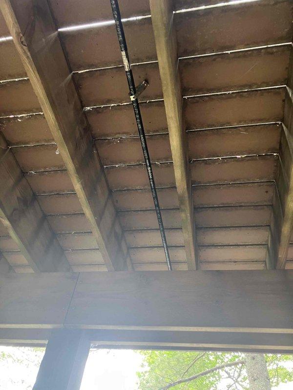 Approved and sold estimate for gas piping installation work. Inspected underside of deck structure where new gas line routing will be installed, documenting existing conditions including exposed joists, current utility runs, and available pathways for pipe installation. Photographed structural elements and clearances to finalize installation plan for natural gas piping project.