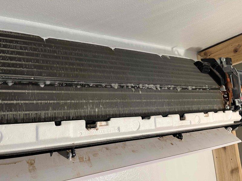 Responded to after-hours emergency service call for no cooling condition in bedroom mini-split head unit. Upon arrival, found indoor unit experiencing severe icing on evaporator coil with blower motor not operating. Confirmed 24V power supply present from outdoor condenser unit, but control board displayed no indicator lights or response. Visual inspection revealed heavily soiled evaporator coils with significant dust and debris accumulation restricting airflow. Documented internal components with photographs showing contaminated heat exchanger fins and overall unit condition. Diagnosed failed control board as primary cause of no-cool condition, with secondary contributing factor of restricted airflow due to lack of maintenance. Provided estimate for control board replacement and recommended professional coil cleaning to restore proper system operation and prevent future failures.