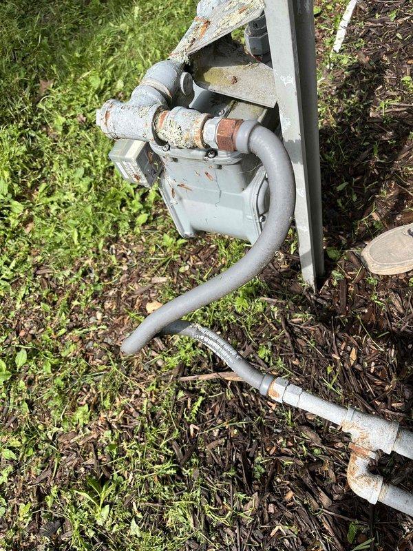 Completed repair work on HVAC system by replacing the blower assembly, inducer motor, and igniter to restore proper heating operation. Documented existing gas meter installation showing weathered flex gas piping connections between the gas main and home's supply line. Property owner requested estimate for converting flexible gas piping section to rigid hard pipe installation for improved durability and code compliance.
