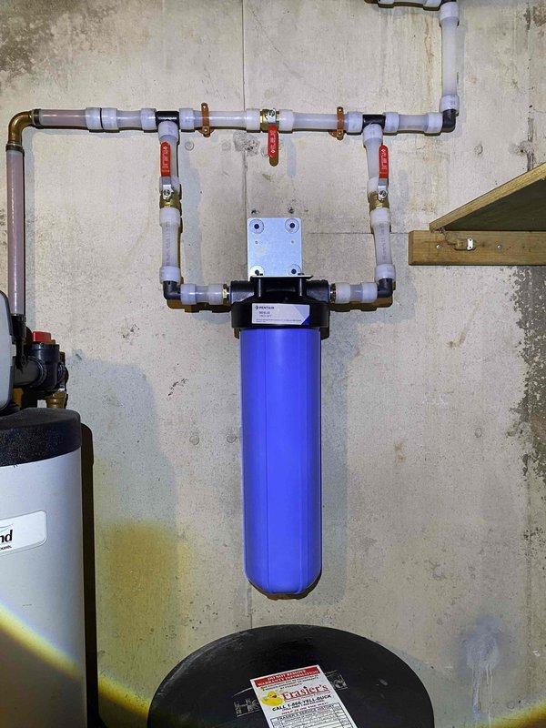 Removed existing acid neutralizer and installed new Water Right IMPBF-1054AN acid neutralizer system with calcite media, top fill port, and new bypass assembly. Replaced injector in water softener unit, replaced o-ring and carbon filter in wall-mounted filter housing, and supplied correct sized wrench for filter maintenance. Replaced water conditioner and filter housing components to restore proper water treatment system operation.