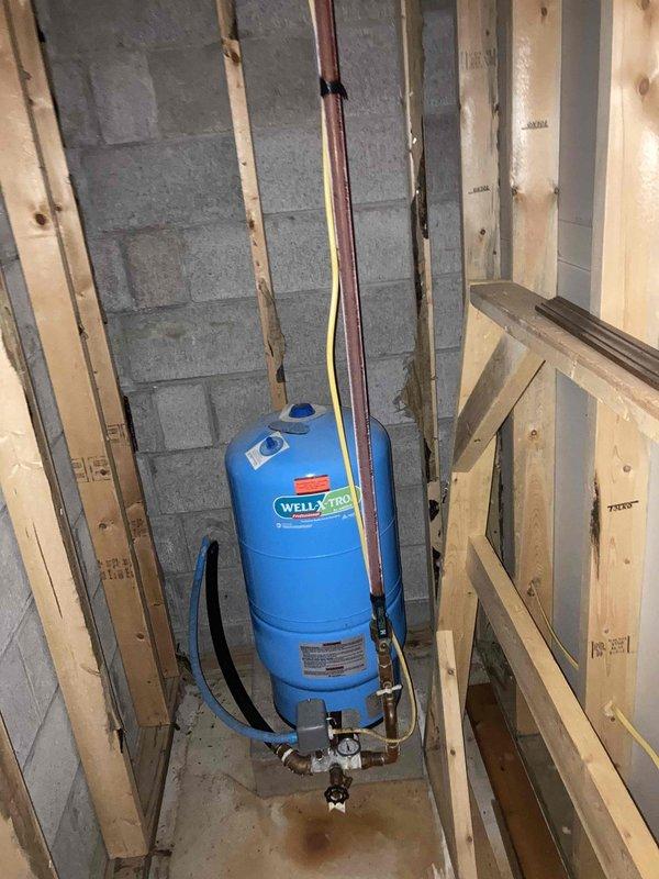 Completed prepaid annual maintenance on water heater system and inspected well pressure tank with associated plumbing connections. Addressed kitchen faucet leak that had developed since previous visit, performed necessary repairs, and verified proper operation of all plumbing fixtures and pressure regulation equipment.