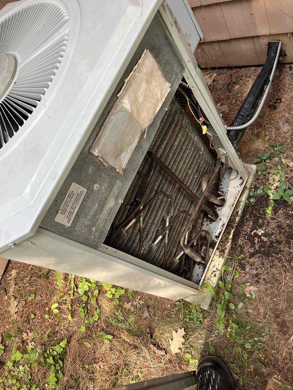 Responded to no cooling call on 10-year-old air conditioning system. Upon arrival, found outdoor condensing unit completely inoperative with no power. Investigated electrical supply and discovered rodent damage to incoming line power cable, which had caused a short circuit. Removed damaged wiring and ran new power cable from crawlspace to condenser disconnect. Restored power to unit, verified proper operation, and confirmed system cooling normally. Photographed damaged wiring and completed repairs.