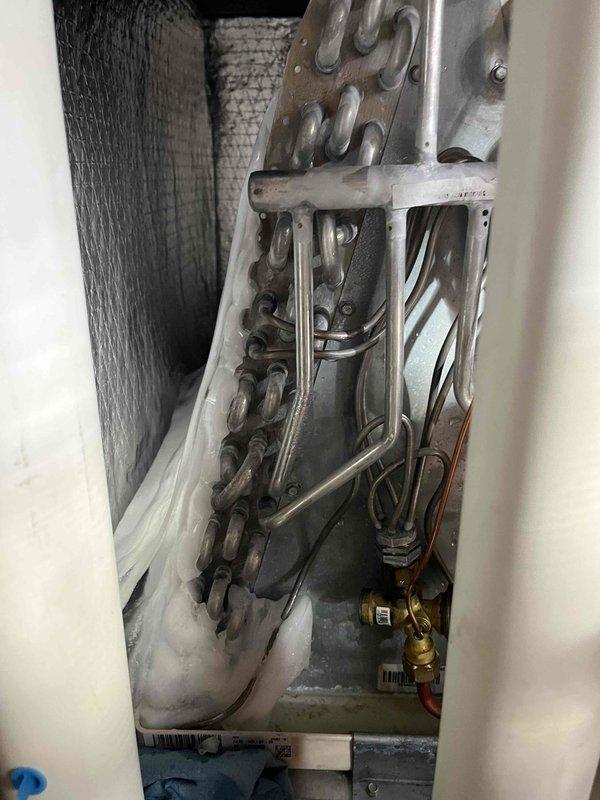 Responded to no cooling complaint with indoor temperature exceeding 80 degrees. Found air conditioning system with frozen evaporator coil and low refrigerant charge. Thawed ice from system and verified refrigerant levels were below manufacturer specifications. Presented customer with option for additional leak detection and testing to identify source of refrigerant loss, which was declined at time of service.