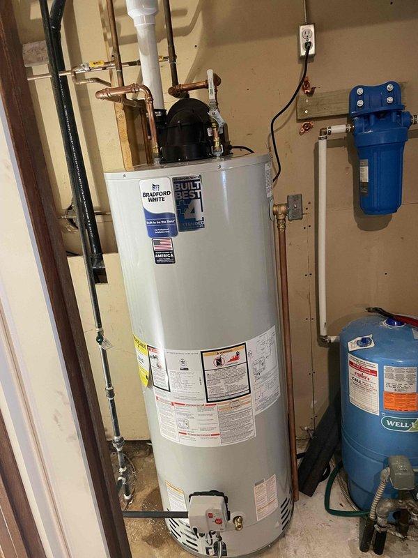 Supplied and installed a 50-gallon Bradford White LP power-vent water heater in the utility room as part of a combination installation with furnace and AC system. Connected all copper supply lines, electrical conduit, and exhaust venting to manufacturer specifications, ensuring proper integration with existing well pressure tank and water filtration system.