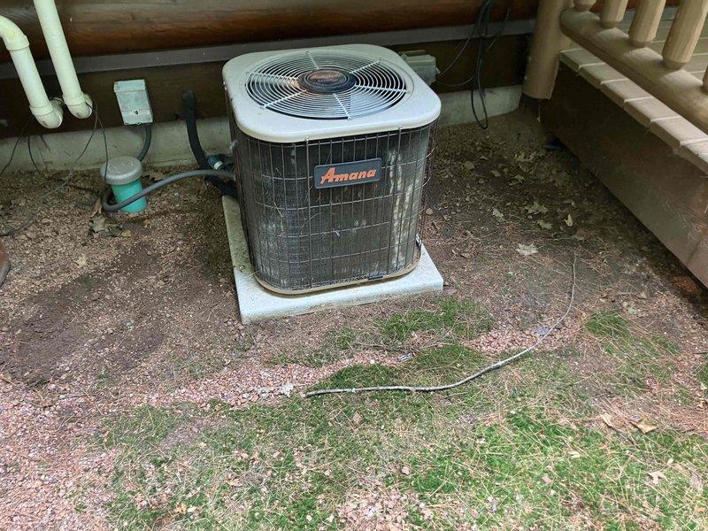 Responded to no cool call on 22+ year old Amana air conditioning system with non-operational outdoor fan. Upon inspection, found failed capacitor with severe corrosion, oxidation, and heat damage at terminals. Replaced defective capacitor and restored system to normal operation.