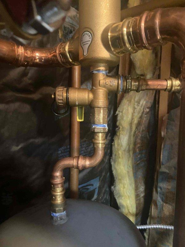 Completed return visit to finish zone valve manifold piping installation on hydronic heating system. Replaced corroded fittings in ceiling using press fittings (four 1" UFS-100P and two 3/4" UFS-075P for Taco zone valves), installed six 1¼" x 1¼" x ¾" tees and two 1¼" x 1¼" x 1" tees to complete manifold assembly. Charged system with Alpha 11 antifreeze and purged all air from heating loops. Resolved leaking fittings, tested all zones for proper operation, and restored system to full heating functionality including both domestic hot water loop and all heating zones.