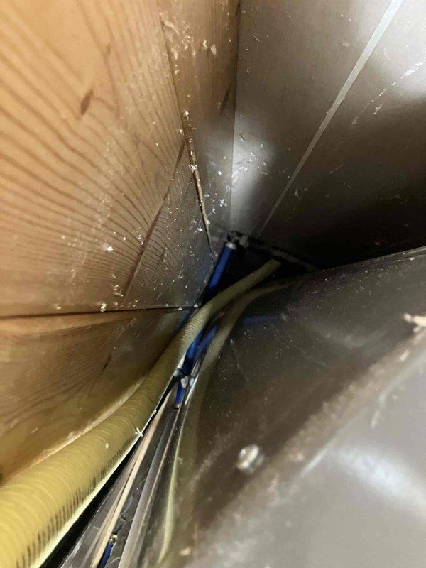 Responded to service call for non-operational crawlspace dehumidifier and non-compliant gas piping. Upon inspection, diagnosed failed blower motor in dehumidifier unit. Identified code violation at gas meter where TracPipe flexible gas line installation did not meet current safety standards. Documented existing conditions with photos showing weathered gas meter assembly with improper piping connections and crawlspace environment with moisture present on surfaces. Provided estimate for blower motor replacement and complete gas line replacement from meter to ensure code compliance.