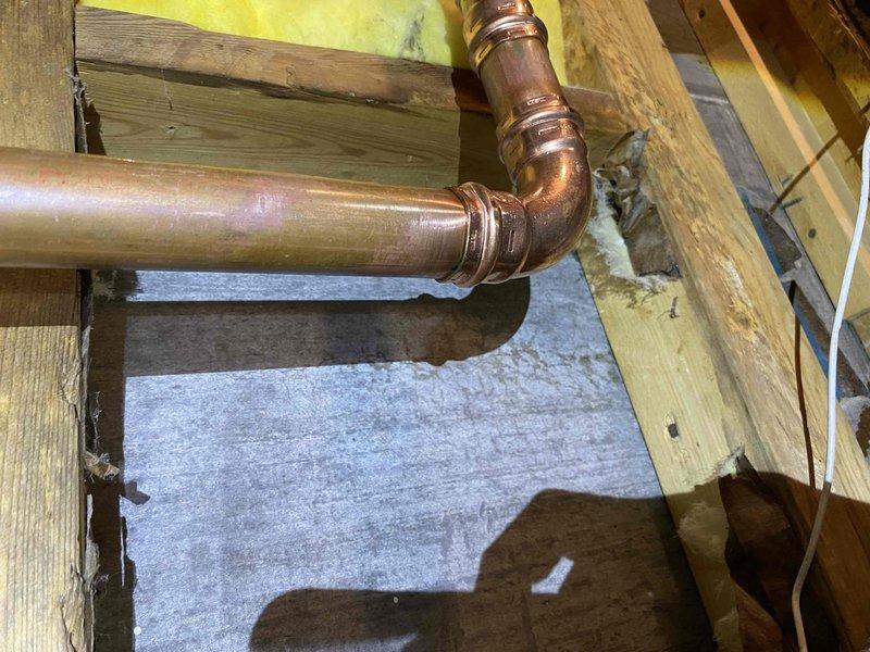 Responded to callback for persistent leaks following previous boiler repipe work. Identified and addressed three leak points: drain valve, 1.25" copper 90-degree elbow, and 3/4" copper 90-degree elbow. Cut out defective fittings and installed new copper fittings with proper soldering techniques to ensure watertight connections and system integrity.